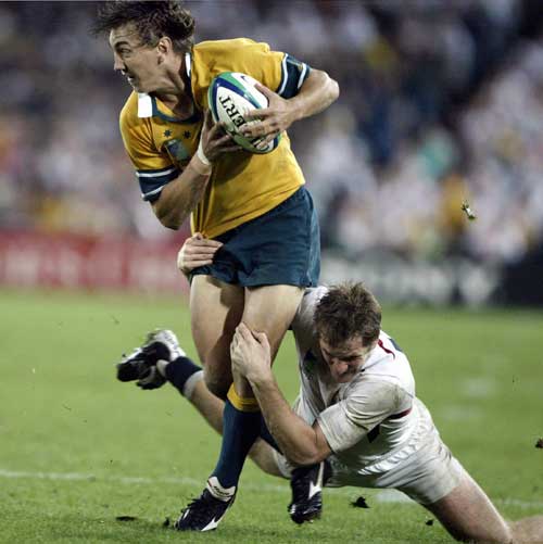 Australia's Mat Rogers is tackled by Will Greenwood