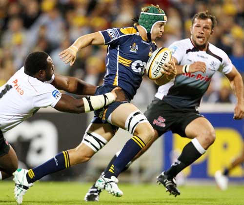 The Brumbies' Stephen Hoiles stretches the Sharks' defence
