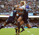 The Bulls' Wynard Olivier is tackled by the Blues' defence