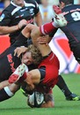 The Sharks' Patrick Lambie tackles the Reds' Quade Cooper