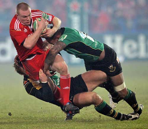 Munster's Keith Earls is tackled by the Northampton defence