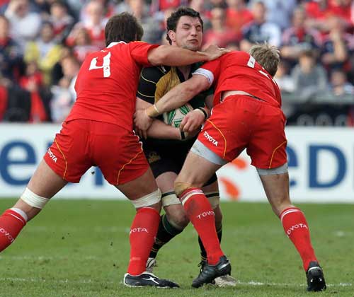 Northampton's Phil Dowson is tackled by the Munster defence