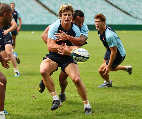 The Waratahs' Berrick Barnes is tackled during a training session