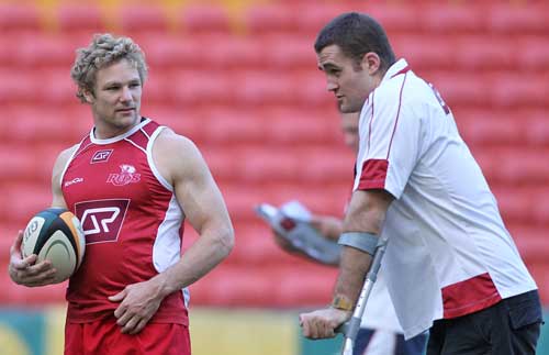 The Reds' Peter Hynes talkes to injured team-mate James Horwill