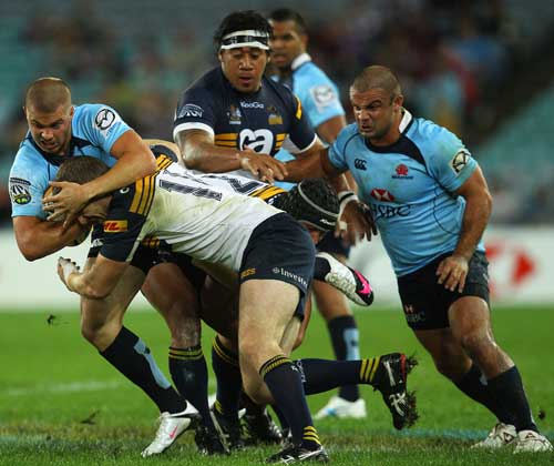 Waratahs wing Drew Mitchell feels the force of the Brumbies' defence