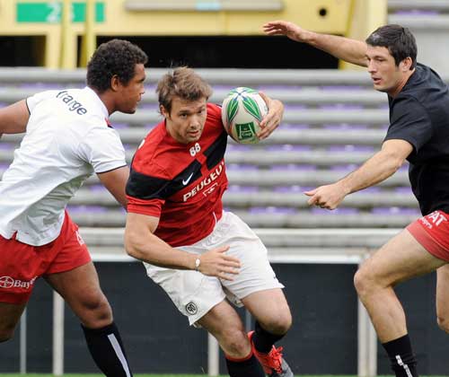 Toulouse wing Vincent Clerc breaks past Thierry Dusautoir and Jean Bouilhou during training