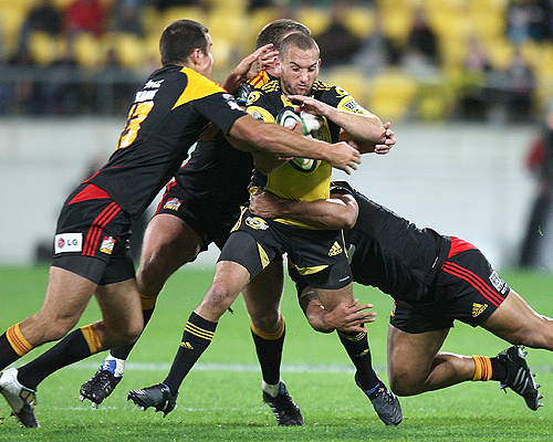 Hurricanes fly-half Aaron Cruden is surrounded by Chiefs tacklers