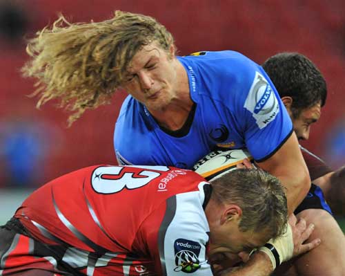 The Western Force's Nick Cummins is tackled by the Lions' Deon van Rensburg
