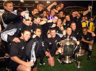 The All Blacks celebrate with the 2003 Tri Nations trophy and the Bledisloe Cup after their 21-17 victory over Australia, New Zealand v Australia, Tri Nations, Eden Park, August 16 2003.