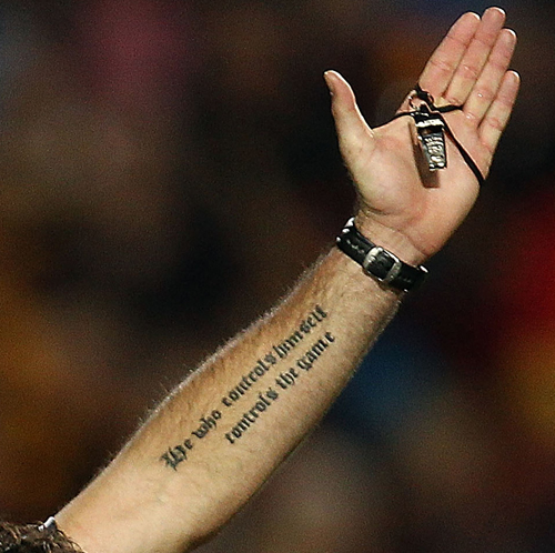 Referee Steve Walsh shows off a tattoo on his arm