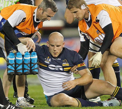 Brumbies hooker Stephen Moore is assisted after breaking his jaw
