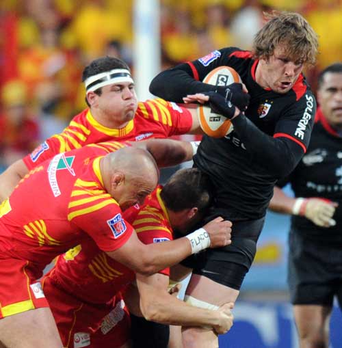 Toulouse No.8 Shaun Sowerby is tackled by the Perpignan defence