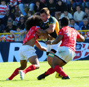CJ Stander of South Africa is tackled by Tongan players 