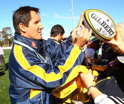 Australia coach Robbie Deans signs an autograph for a fan