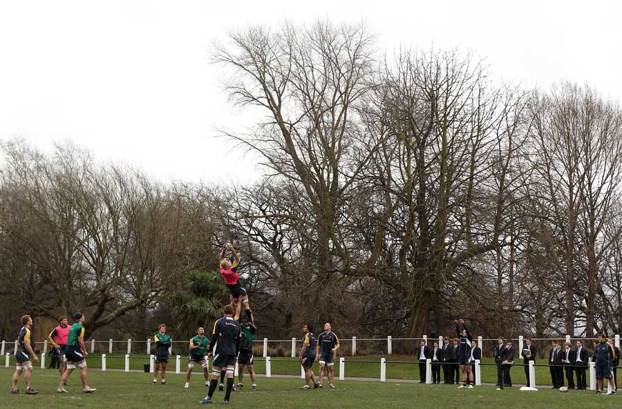The Australian forwards run a lineout drill as pupils look on