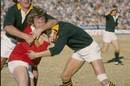 Derek Quinnell is tackled by two Springboks