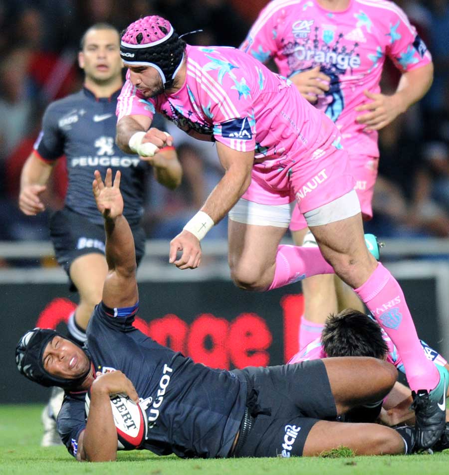Toulouse's Thierry Dusautoir is tackled by Stade Francais' Pierre Rabadan