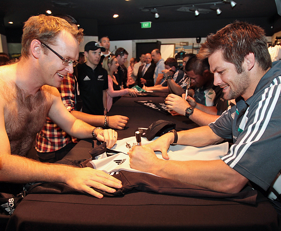 Richie McCaw signs a shirt for a keen fan