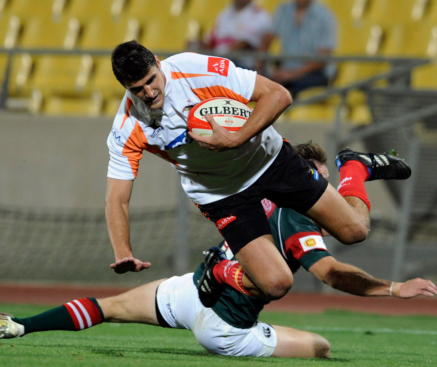 The Cheetahs' Hennie Daniller jumps over a challenge from Micheal Bondesio