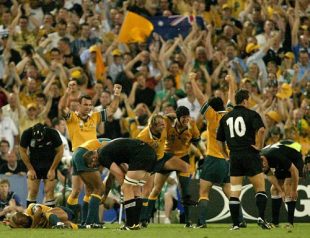 The Australian team celebrate their win as the Australian captain George Gregan lies injured at full-time of the Rugby World Cup Semi-Final match between Australia and New Zealand at Telstra Stadium in Sydney, Australia on November 15, 2003.