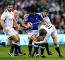 Samoa's Seilala Mapusua is wrapped up by the English defence