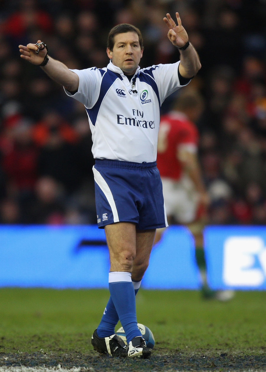 Referee Alain Rolland signals towards the touchline
