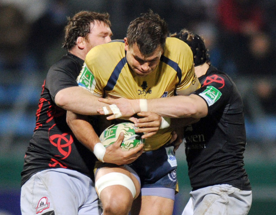 Castres's lock Kirill Kulemin is tackled by two Edinburgh defenders