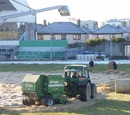Staff rebale the hay that has kept snow off the pitch at the Sportsground to allow Connacht v Harlequins to go ahead