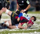 Saracens' Kelly Brown is tackled by Racing Metro's Johnny Leo'o