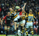 Wasps scrum-half Joe Simpson competes with Saracens wing David Strettle for a high ball