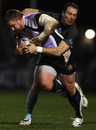 Exeter's Simon Alcott is wrapped up by Mickael Forest