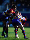 Scarlets' Sean Lamont is tackled by David Marty and Maxime Mermoz of Perpignan