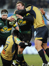 Northampton No.8 Roger Wilson is wrapped up by the tacklers
