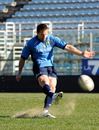 Italy fly-half Kris Burton puts boot to ball during training