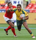Seilame Tukuafu of Tonga tries to lay his hands on Daniel Yakapo of Australia