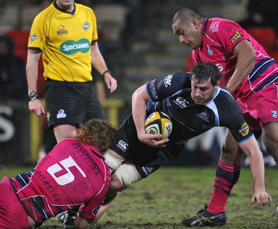 Glasgow's Alastair Muldowney is tackled by the Blues' Paul Tito and Ma'ama Molitika 
