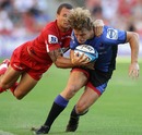 Western Force's Nick Cummins is tackled by the Reds' Quade Cooper