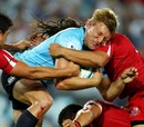The Waratahs' Lachie Turner is wrapped up by the Reds
