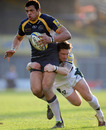 London Irish fly-half Ryan Lamb clings on to a tackle on Leeds' Luther Burrell 