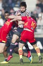 Stade Francais' Quentin Valancon is wrpaaed up by the Perpignan defence
