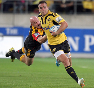 The Chiefs' Brendon Leonard launches to tackle the Hurricanes' Andre Taylor 