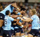 The Waratahs players swamp Sitaleki Timani after his late try