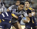 The Hurricanes' Hosea Gear is wrapped up by the Brumbies