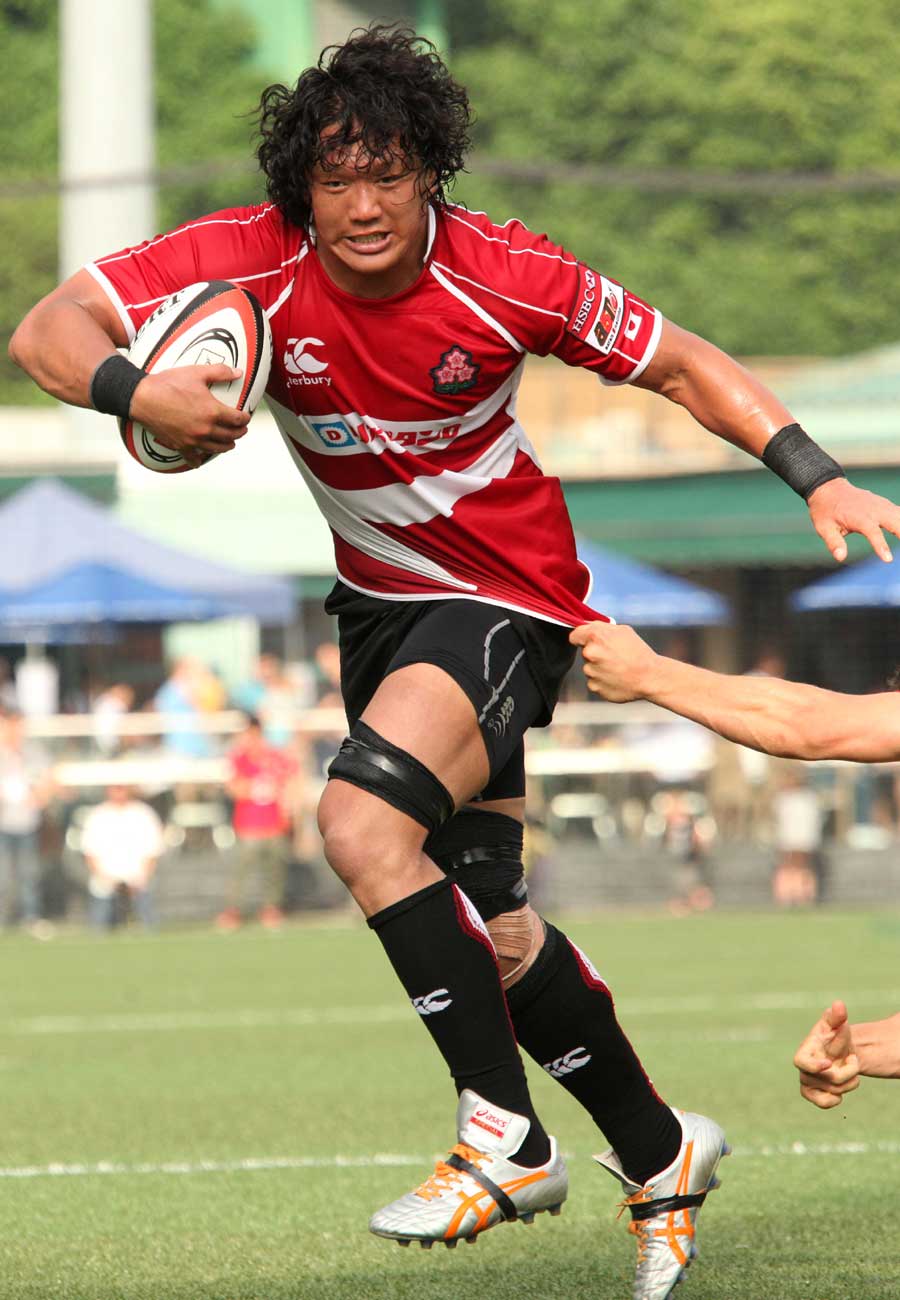 Takashi Kikutani of Japan runs with the ball