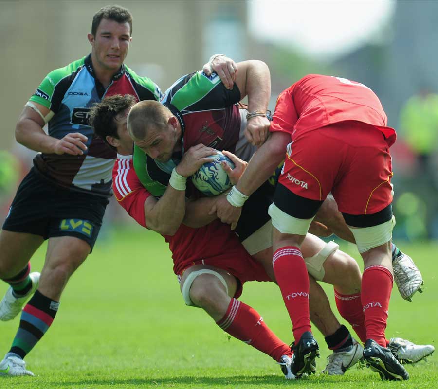 Quins lock George Robson is shackled by the Munster defence