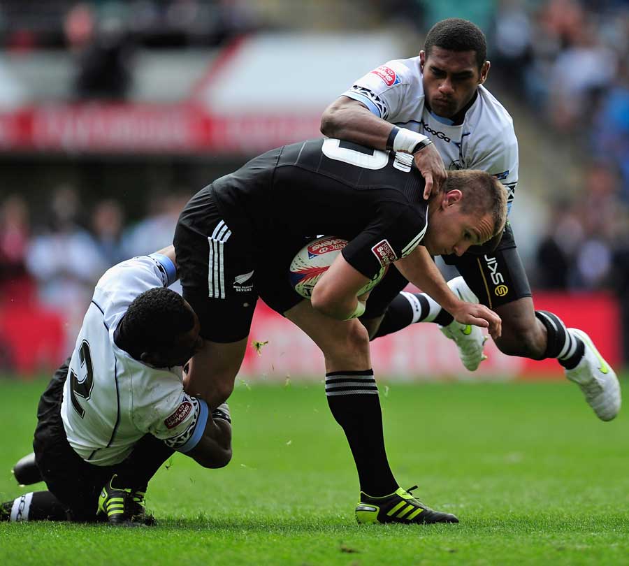New Zealand's Toby Arnold is wrapped up by the Fiji defence
