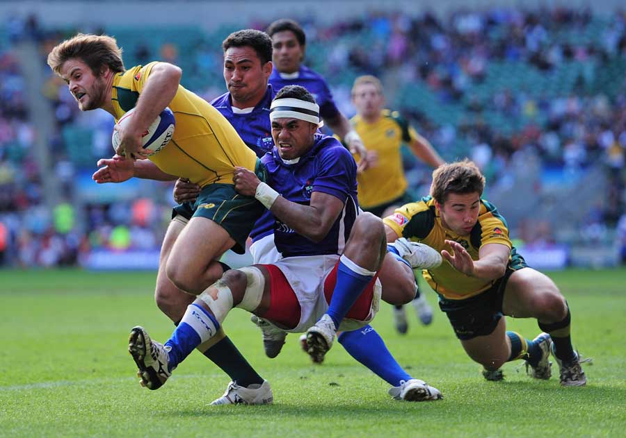 Australia's Jacob Taylor is tackled by Samoa's Tom Iosefo