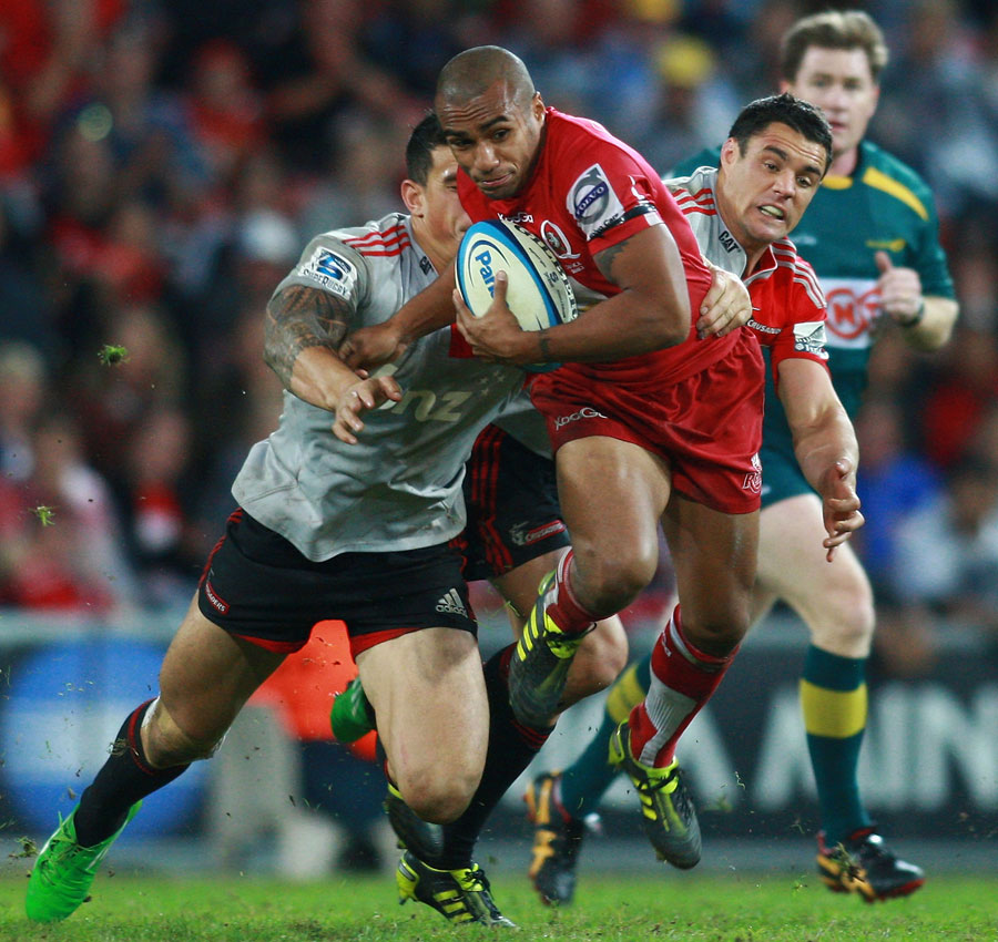 Reds scrum-half Will Genia fends off the Crusaders' Dan Carter and Sonny Bill Williams