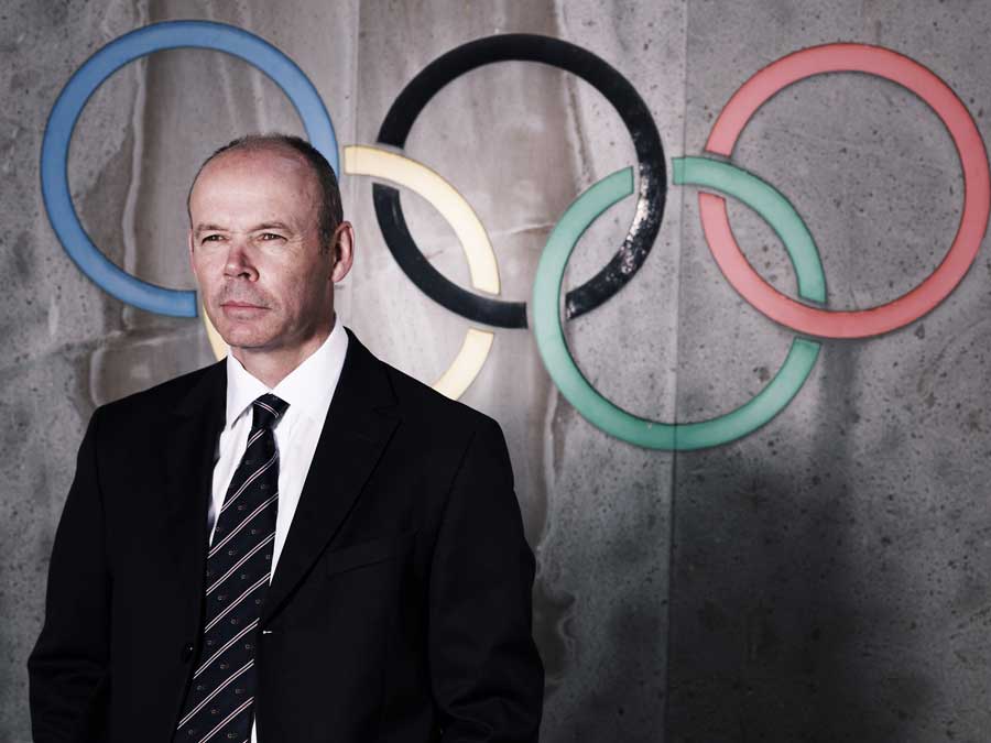 Clive Woodward poses in front of the Olympics logo