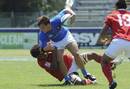 Italy outside centre Giovanni Alberghini is tackled